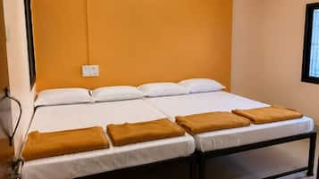 Una habitación de hotel con cama, ventilador de techo, aire acondicionado de pared y ventana.