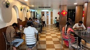 A restaurant with checkered flooring, metal chairs, and tables. - Shri Radha Govind Bhakt Niwas and Hotel (Pandharpur)