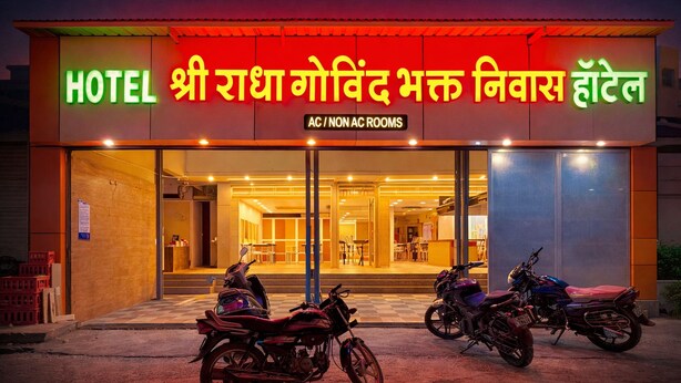 A hotel with a sign indicating AC and non-AC rooms, and two motorcycles parked in front. - Shri Radha Govind Bhakt Niwas and Hotel (Pandharpur)