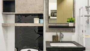 Une salle de bain moderne équipée de toilettes, d’un lavabo et d’un miroir.