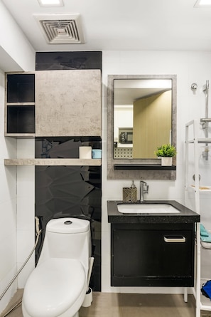 Ein modernes Badezimmer mit Toilette, Waschbecken und Spiegel.