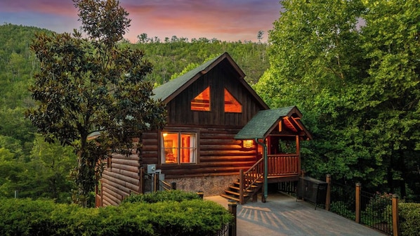 A log cabin with a porch and a staircase leading to the entrance. - Cubby Bear Cabin • Cabin with Mountain Views • Pool Table & Arcade (Sevierville)