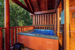 A wooden hot tub with a built-in bench, surrounded by a wooden deck with railings. - Cubby Bear Cabin • Cabin with Mountain Views • Pool Table & Arcade (Sevierville)