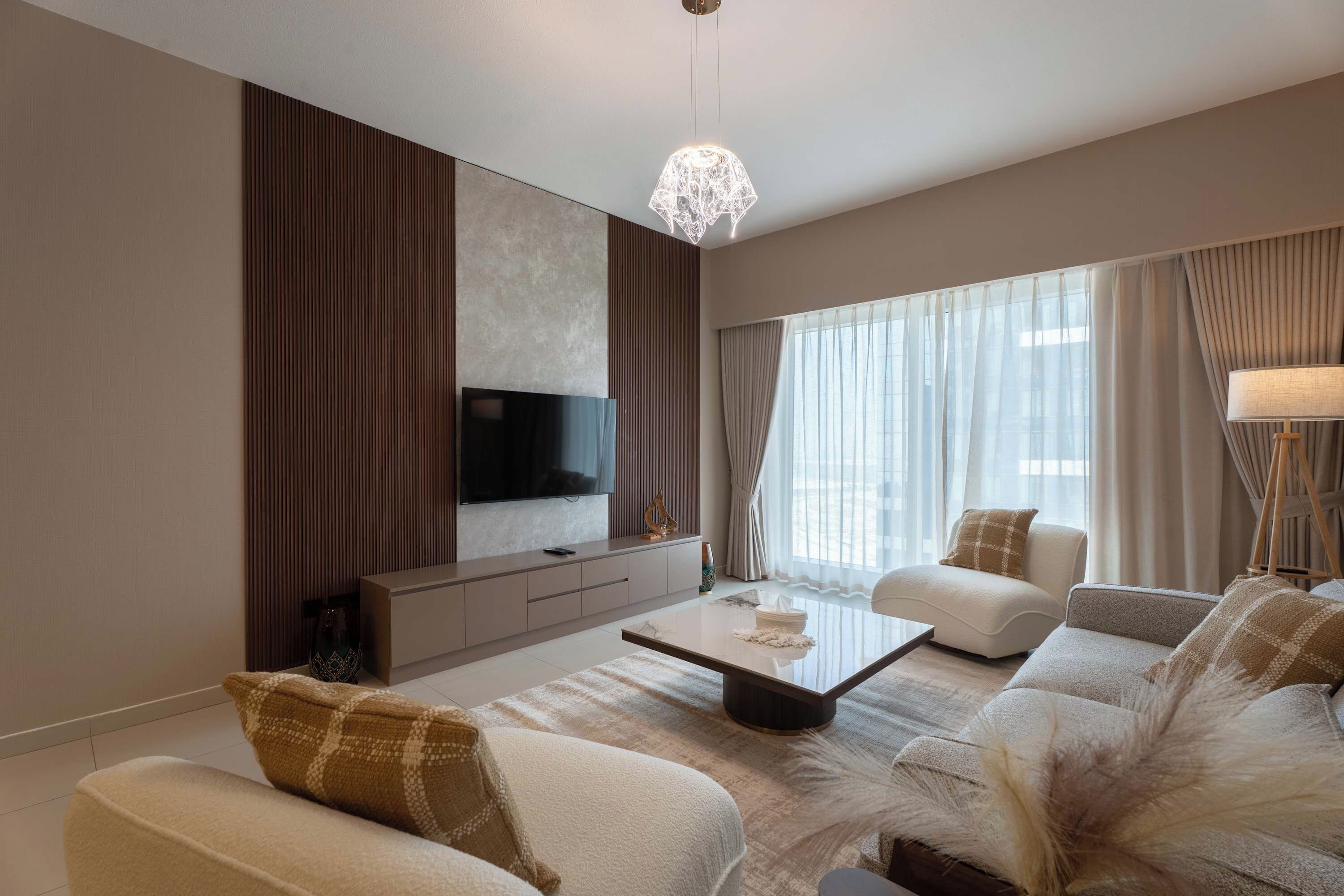 A modern living room with a flat-screen TV, a sofa set, a coffee table, and a decorative lamp.