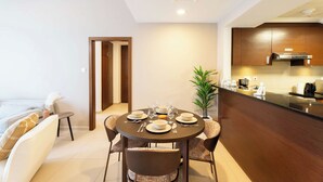 A modern kitchen with a dining area, equipped with a stove, microwave, and a coffee machine. - Vanilla Homes Premium 1BR in Gate Tower (Abu Dhabi)