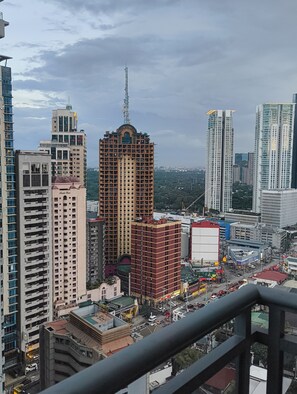 A high-rise building with a central tower, surrounded by other tall buildings, and a busy street below. - A Cozy Unit with Hotel-Like Luxury Amenities & Near Mall (Makati City)