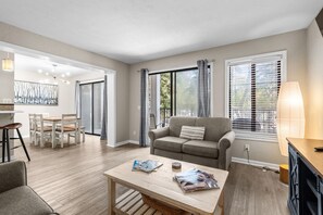A spacious living room with a sofa, a coffee table, and a dining area with chairs. - A241 at The Myrtle Beach Resort (Myrtle Beach)