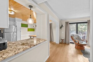 A modern kitchen with a marble countertop, stainless steel appliances, and a hanging pendant light. - A245 Myrtle Beach Resort (Surfside Beach)