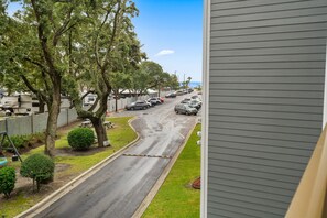 A street view with parked cars, trees, and a residential building. - A245 Myrtle Beach Resort (Surfside Beach)