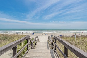 A wooden boardwalk leading to a beach with people and umbrellas. - A239 at The Myrtle Beach Resort (Surfside Beach)