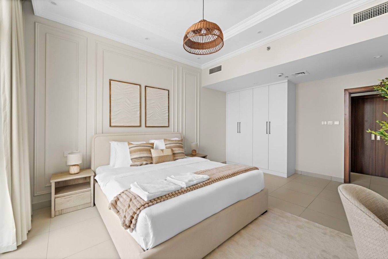A bedroom with a bed, bedside tables, a wardrobe, and a hanging light fixture.