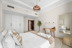 Ein Hotelzimmer mit einem großen Bett, einem Schreibtisch, einem Stuhl, einem Spiegel und einem Kleiderschrank.