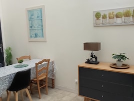 Un comedor con una mesa, sillas, una lámpara y un mueble con cajones.