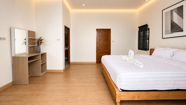 Quarto moderno com cama de madeira, mesa de cabeceira, espelho e quadro na parede.