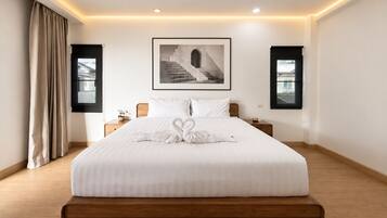 A hotel room with a large bed, a framed picture above the bed, and two bedside tables.