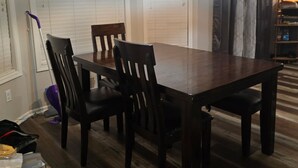 A dining area with a wooden table and chairs, a ceiling light fixture, and a door with blinds. - Charming 3-bedroom house in Rex near Atlanta (Rex)