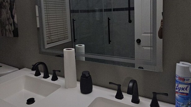 A bathroom with two sinks, a large mirror, and a Lysol disinfectant spray bottle. - Charming 3-bedroom house in Rex near Atlanta (Rex)