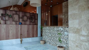 A modern interior with wooden paneling, stone accents, and a patterned rug.