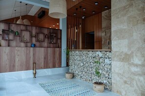 A modern interior with wooden paneling, stone accents, and a patterned rug. - Shakaryan Rancho&Restaurant (Dsegh)