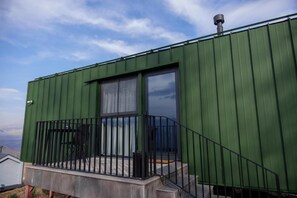 A green metal building with a balcony and a window. - Shakaryan Rancho&Restaurant (Dsegh)