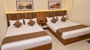 A hotel room with two beds, a wooden headboard, a bedside table with a phone, and framed pictures on the wall. - Hotel House Of Awadh (Faizabad)