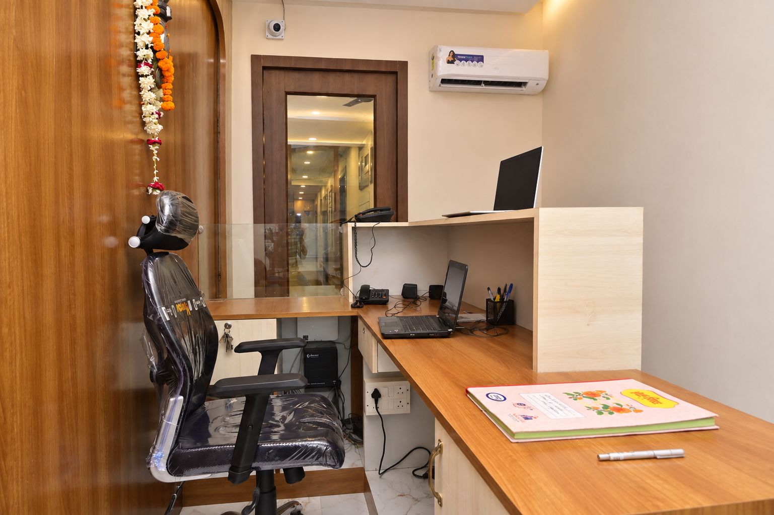 A home office with a desk, chair, computer, and an air conditioner.