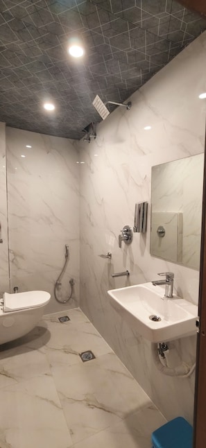 A modern bathroom with a white marble floor, two sinks, a shower, and a mirror. - Hotel House Of Awadh (Faizabad)