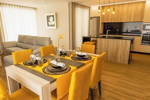 A modern dining area with yellow chairs and a wooden table set for four. - Nature Hill 1 by Portugal Active (Viana do Castelo)