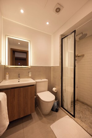 A modern bathroom with a vanity, toilet, and shower area. - Lovely Home at Elevens by Spacey #1 (cairo)