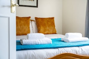 A hotel room with a bed, two pillows, a blue blanket, and two folded towels. - Potter`s House | Central 2 Bed, Sleeps 4 (Edinburgh)