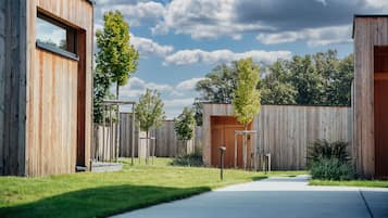 A modern building with a wooden facade, a clear sky, and a well-maintained lawn.