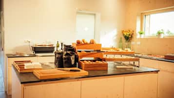 A buffet setup with various food items and serving utensils.