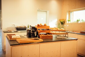 A buffet setup with various food items and serving utensils.