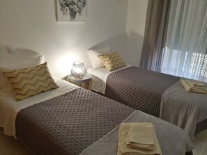 Une chambre d’hôtel avec deux lits, une lampe de chevet et un tableau au mur.