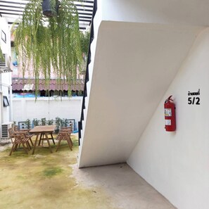 Ein Zimmer mit weißer Wand, an der ein Feuerlöscher angebracht ist, und der Zimmernummer '5/2'.