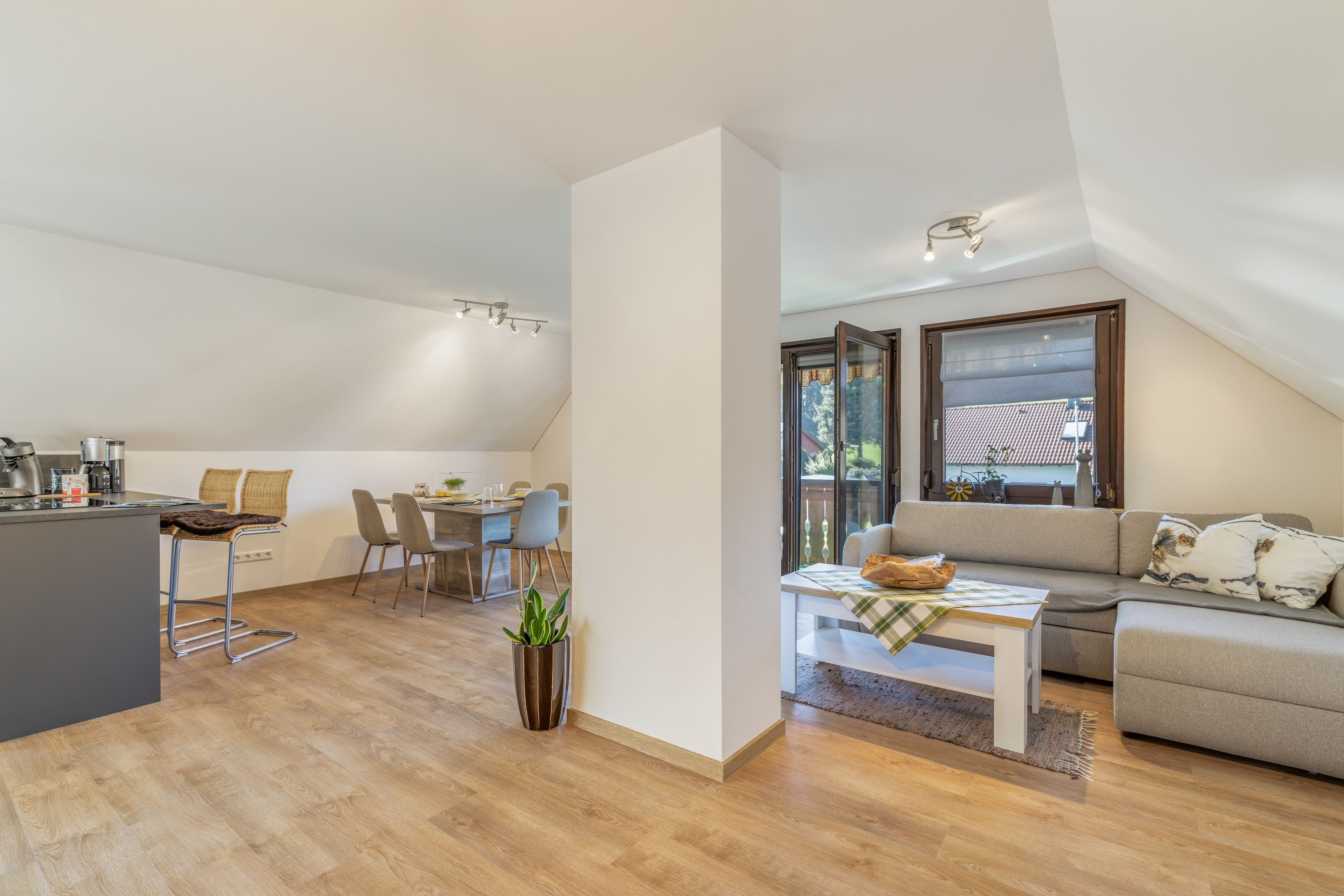 A modern loft apartment with a kitchen, dining area, and living space.