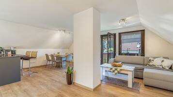 A modern loft apartment with a kitchen, dining area, and living space.