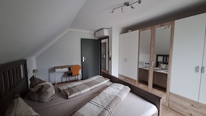 Ein Schlafzimmer mit einem Schlafboxbett, einem Schreibtisch und einem Stuhl.