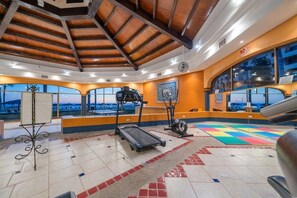 Une salle de sport équipée de matériel d’exercice, dotée d’une grande fenêtre et offrant une vue sur le paysage.