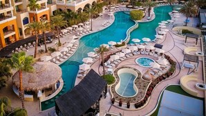 Et resort med flere swimmingpools, loungeområder og en central gårdsplads.