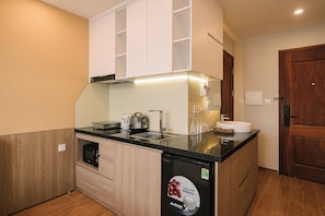 A compact kitchen with a microwave, kettle, and a coffee machine. - An Yên Island (Ba Đình)