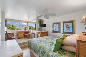 A bedroom with a bed, desk, chair, and a view of the outdoors. - Relaxing Oceanview Condo - Kealia 607 (Kihei)