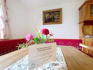 Ein Zimmer mit einem Holztisch, einem gerahmten Gemälde an der Wand und einem Willkommensschild.