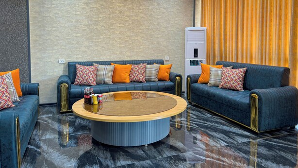 Una sala de estar moderna con dos sofás, una mesa de centro y un aire acondicionado de pared.