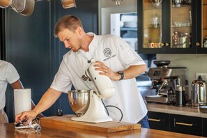 A chef in a white uniform with 'PRIVATE CHEF' text, standing in a kitchen with a mixer on the counter. - Exclusive & Secure, 5-Star Private Country House Estate in Constantia, Cape Town (Cape Town)