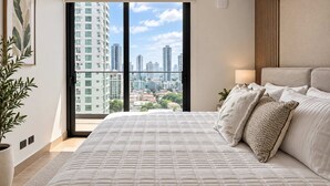 Un dormitorio con una cama grande, vistas a la ciudad y un equipo de aire acondicionado.