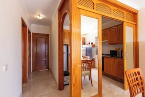 A hallway leading to a kitchen with wooden cabinets and a dining area. - South-Facing Duplex in Los Cristianos (Los Cristianos)