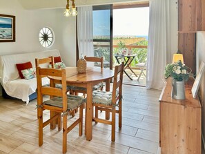 A cozy room with a wooden dining table, chairs, a sofa, and a view of the outdoors. - Holiday Home in La Palma for 4 (Fuencaliente de la Palma)