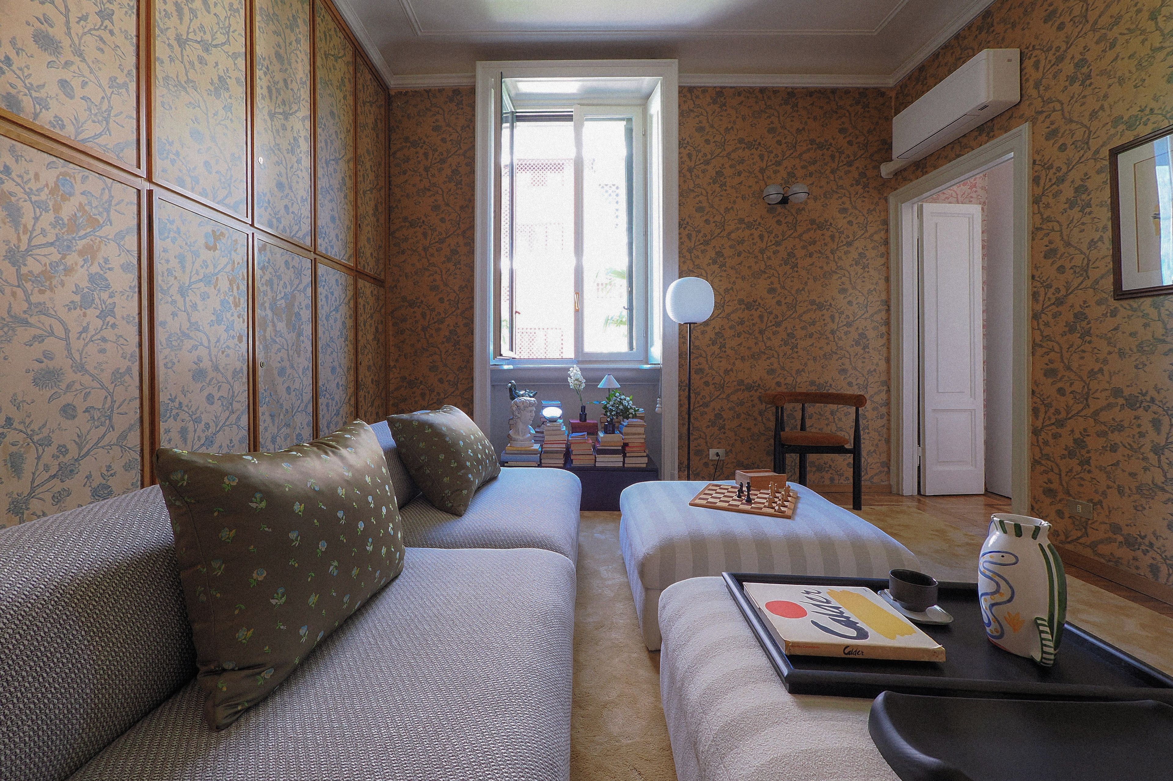 Ein Wohnzimmer mit einer Couch, einem kleinen Tisch mit Schachbrett und einem Fenster mit Blick.