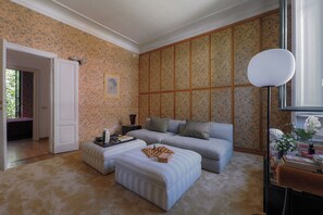 A room with a sofa, ottoman, and a chessboard. There is a door leading to another room. - Contempora - Casa Osti - Designer Villa with Garden in the City Center (Milano)